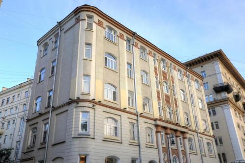 A historic building with a green roof and white walls featuring decorative window frames, located on Prechistenka street in Moscow.