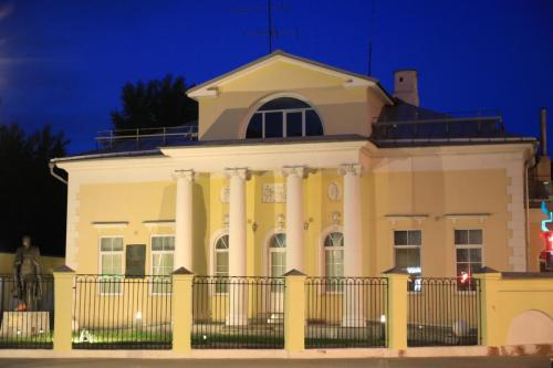 A historic building with a green roof and white walls featuring decorative window frames, located on Prechistenka street in Moscow.